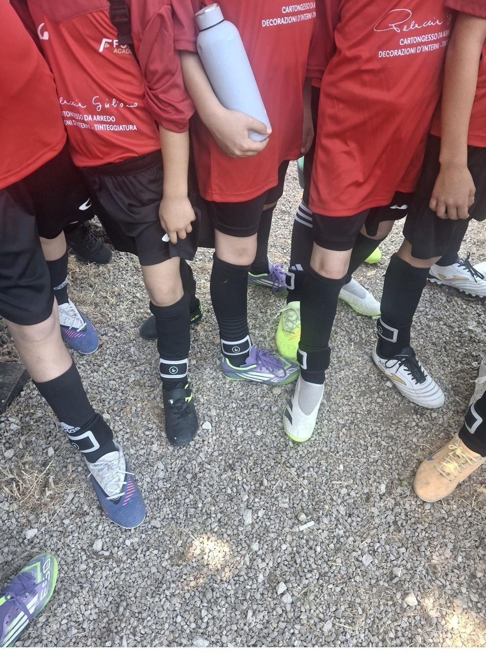 Giovani calciatori con il sensore SoccerQ indossato alla caviglia sopra il calzettone